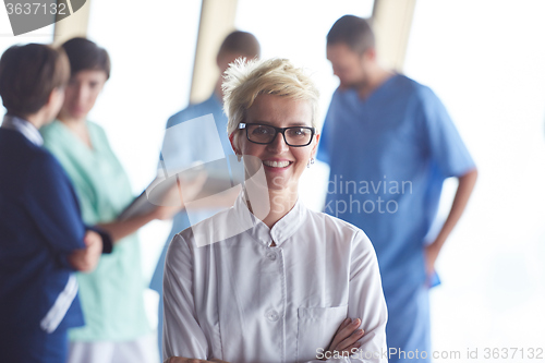 Image of female doctor with glasses and blonde hairstyle standing in fron