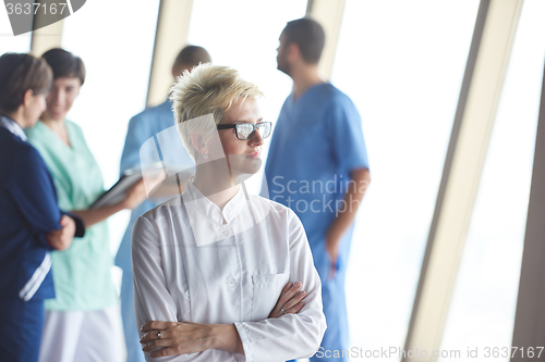 Image of female doctor with glasses and blonde hairstyle standing in fron