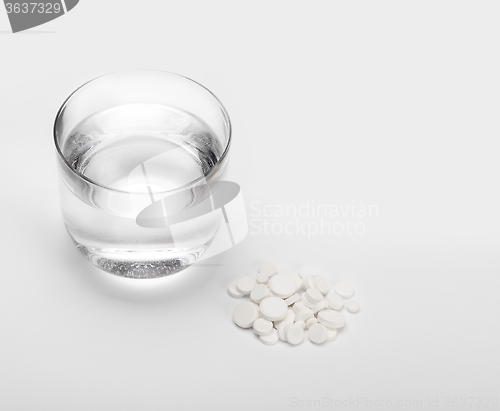 Image of tablets and pills and glass of water