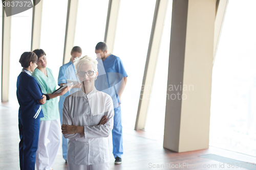 Image of female doctor with glasses and blonde hairstyle standing in fron