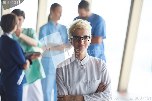 Image of female doctor with glasses and blonde hairstyle standing in fron