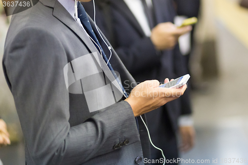 Image of Businessmen using their cell phones on subway.