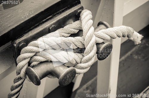 Image of Rope tied to bollard sailboat, sepia