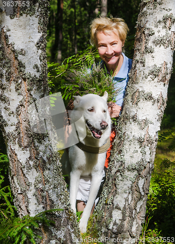Image of Portrait of a woman with a dog on a walk in the woods