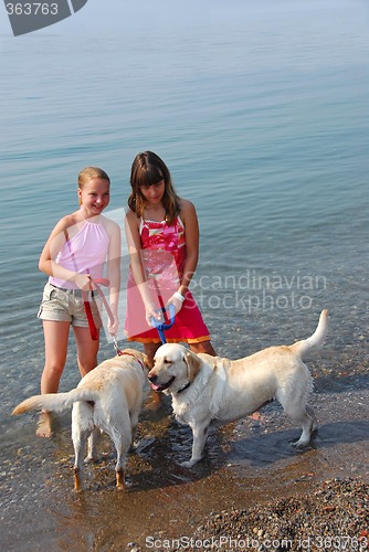 Image of Two girls playing with dogs