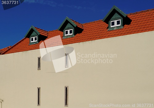 Image of A house with red tile roof and three garrets