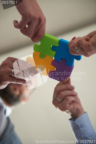 Image of business people group assembling jigsaw puzzle