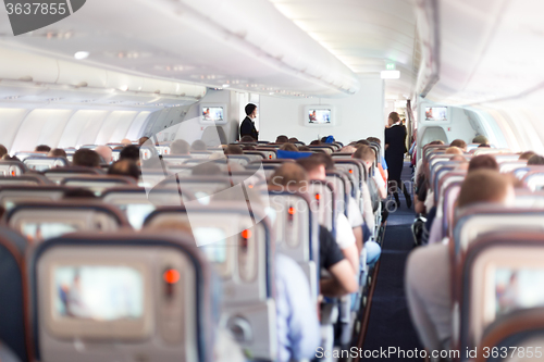 Image of Interior of airplane with passengers on seats.