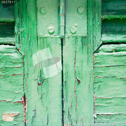 Image of in the old wall a hinged window green wood and rusty metal