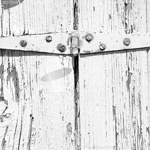 Image of in the old wall a hinged window green wood and rusty metal