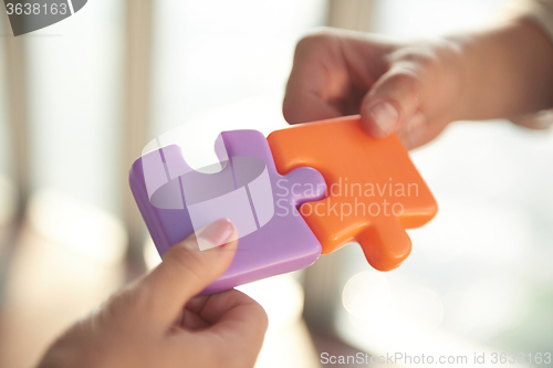 Image of business people group assembling jigsaw puzzle