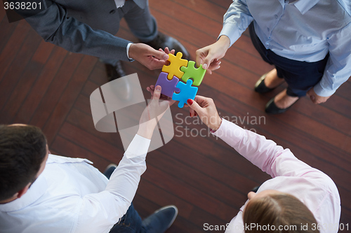 Image of business people group assembling jigsaw puzzle