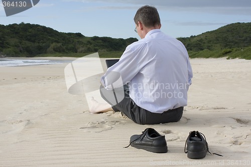 Image of Businessman with laptop on the beach