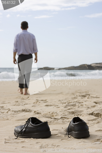 Image of Manager walking barefoot on the beach