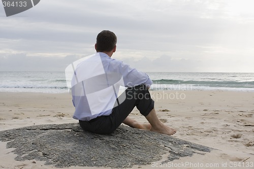 Image of Businessman sitting on the beach