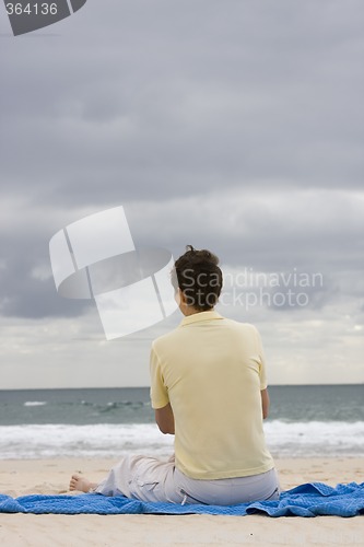 Image of Woman sitting on the beach