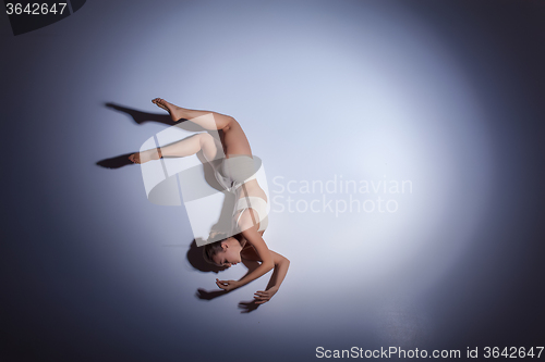 Image of Young beautiful dancer in beige swimwear dancing on lilac background