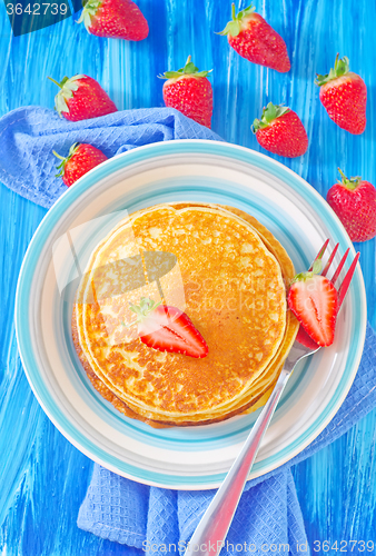 Image of pancakes on plate and fresh strawberries