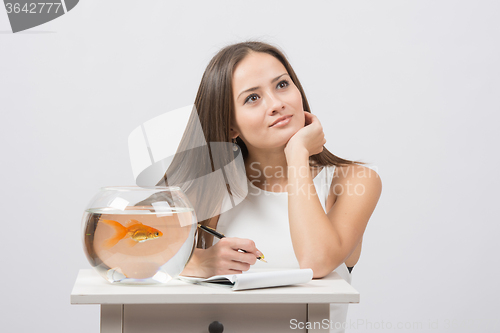 Image of She thought about writing in a notebook desire to fulfill a goldfish
