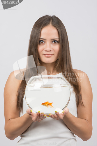 Image of Joyful young girl with an aquarium with goldfish in hands