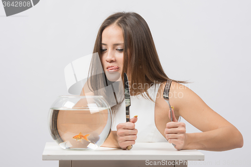 Image of She licked and wants to eat the little goldfish