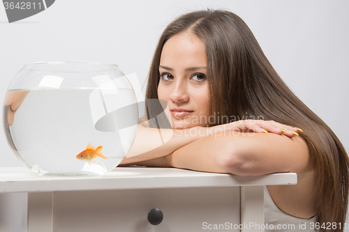 Image of She thought watching the little goldfish in an aquarium