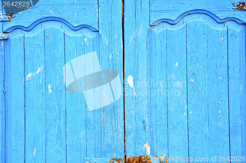 Image of dirty stripped paint in the blue wood door  