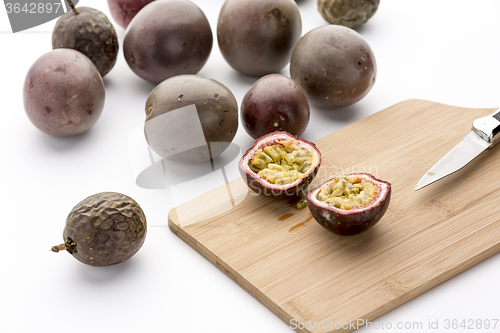 Image of Freshly halved Passion Fruit On A Bamboo Board