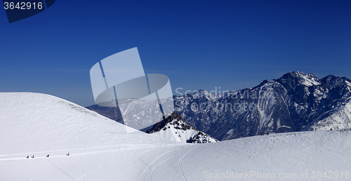 Image of Snowboarders move on footpath to off piste slope at sun day