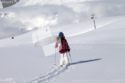 Image of Girl on skis in off-piste slope with new fallen snow at nice day