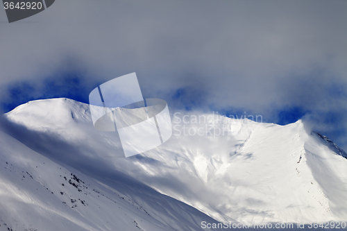 Image of View on sunlight evening off-piste slope in mist