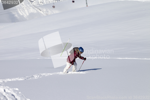 Image of Little skier on off-piste slope with new fallen snow at sun day