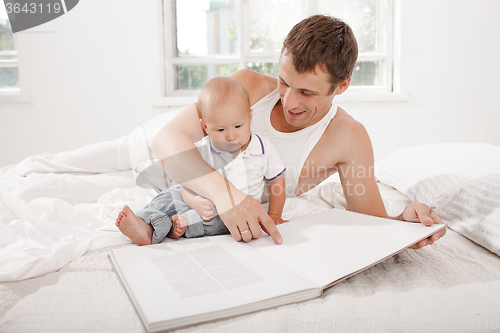 Image of Father and baby together reading book