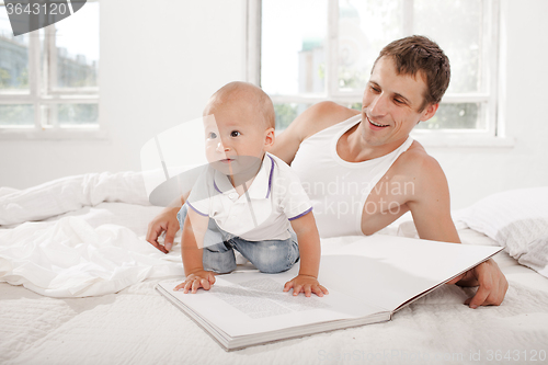 Image of Father and baby together reading book