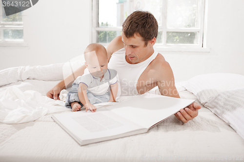 Image of Father and baby together reading book