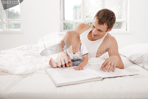 Image of Father and baby together reading book