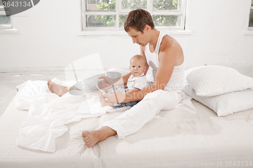 Image of Young father and his nine months old son with digital tablet