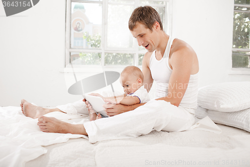 Image of Young father and his nine months old son with digital tablet