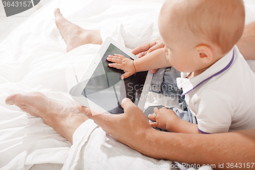 Image of Young father and his nine months old son with digital tablet