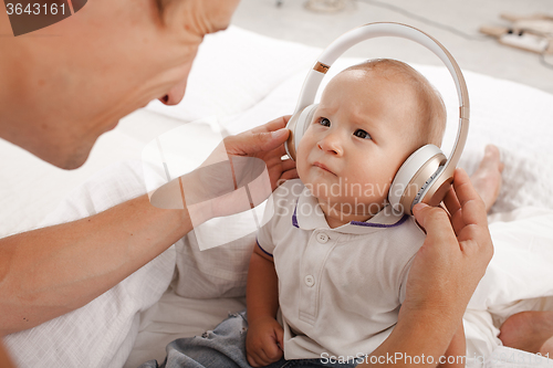 Image of young father with his nine months old som on the bed at home