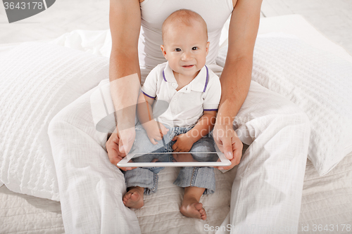 Image of Young father and his nine months old son with digital tablet