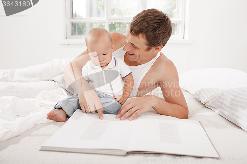 Image of Father and baby together reading book