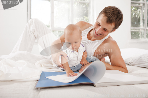 Image of Father and baby together reading book