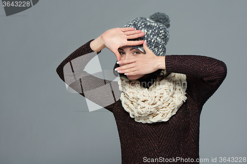 Image of Woman in winter clothing making a frame with her hands