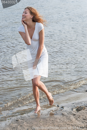 Image of Pretty woman in a white dress on coast