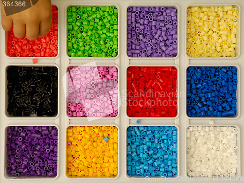 Image of Child playing with toy pearls