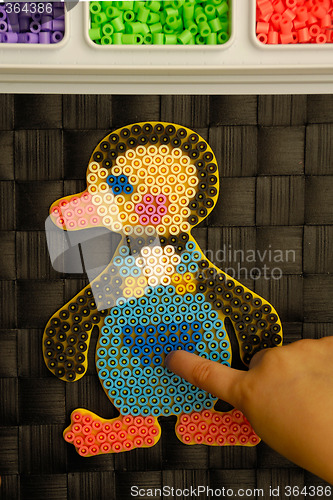 Image of Child playing with toy pearls