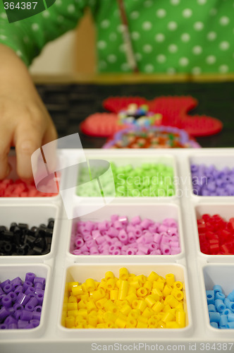 Image of Child playing with toy pearls
