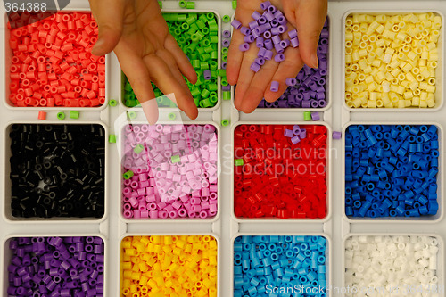Image of Child playing with toy pearls