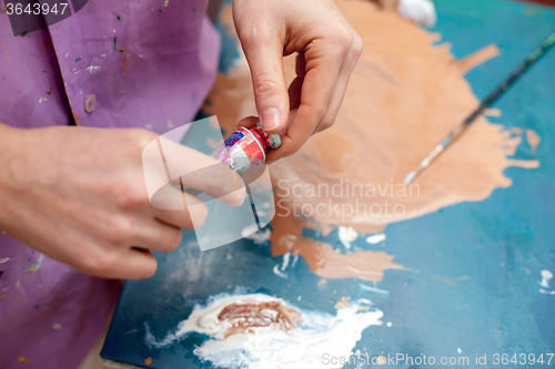 Image of Artist\'s hands close-up on the background of palette 